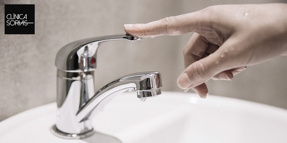 Una mano tocando un grifo