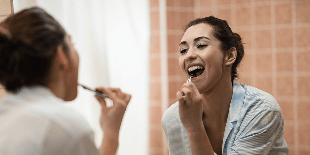 mujer lavándose los dientes