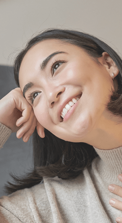 Chica apoyando la cabeza en su mano sonriendo