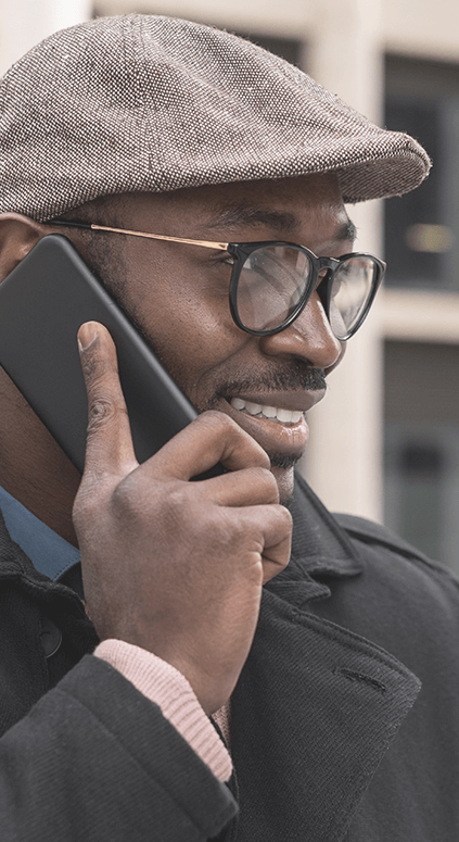 Hombre sonriendo y hablando por teléfono en la calle