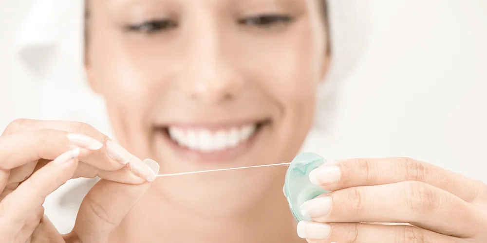 Muejar usando el hilo dental - Clínica Dental Soria - Salamanca