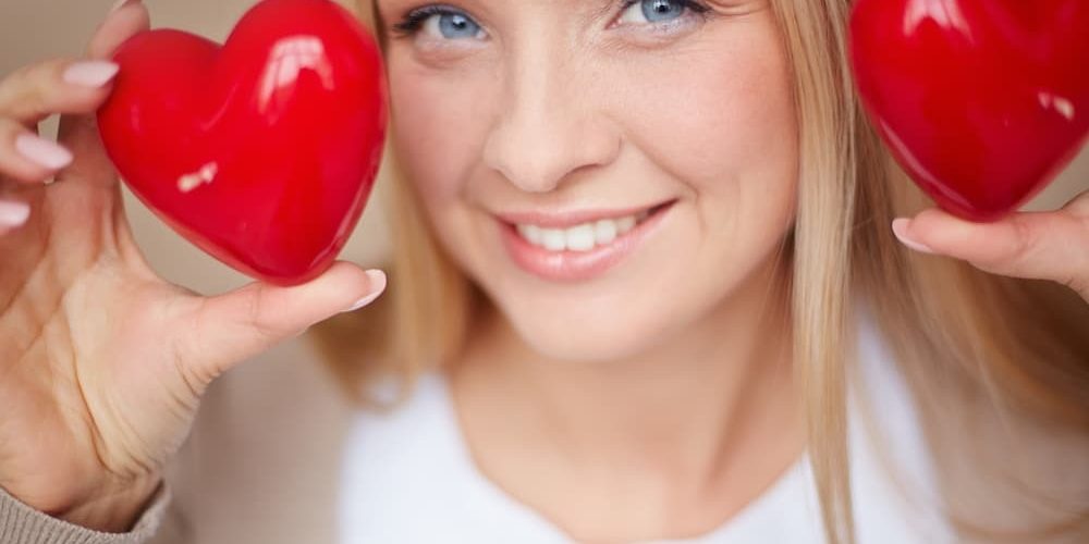Primer plano de una mujer con dos corazones rojos