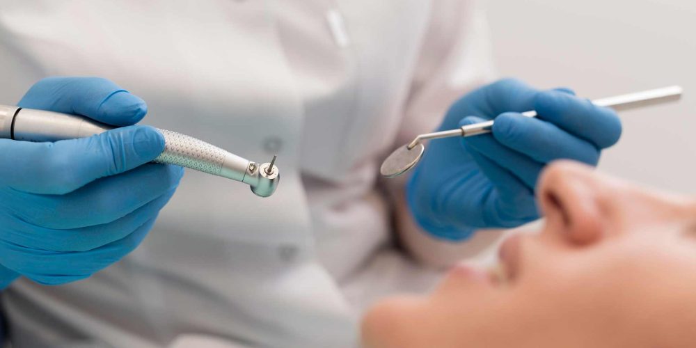Dentista con herramientas en tratamiento de paciente