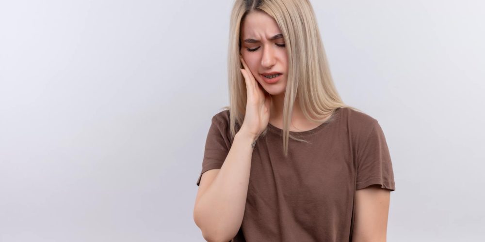 Dolor joven rubia poniendo mano mejilla dolor muelas