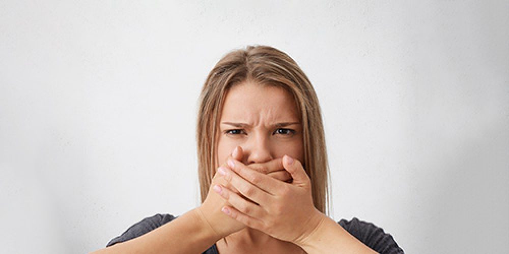 Chica tapándose la boca