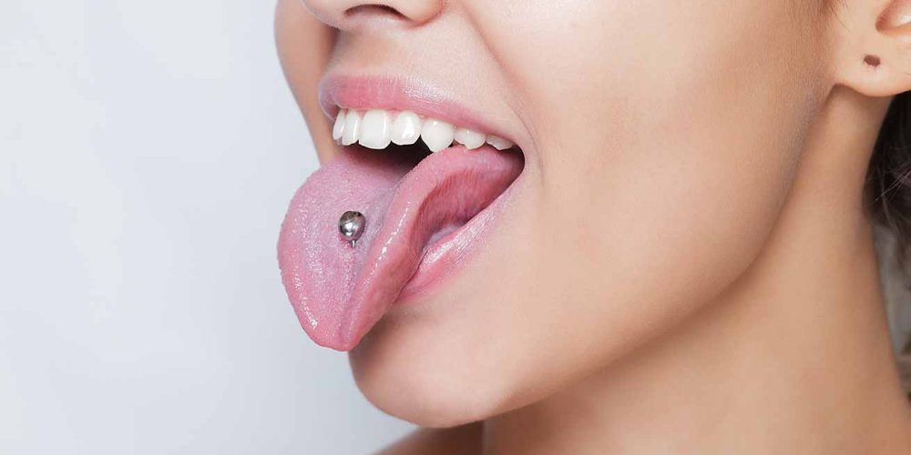 Mujer joven con piercing en la lengua