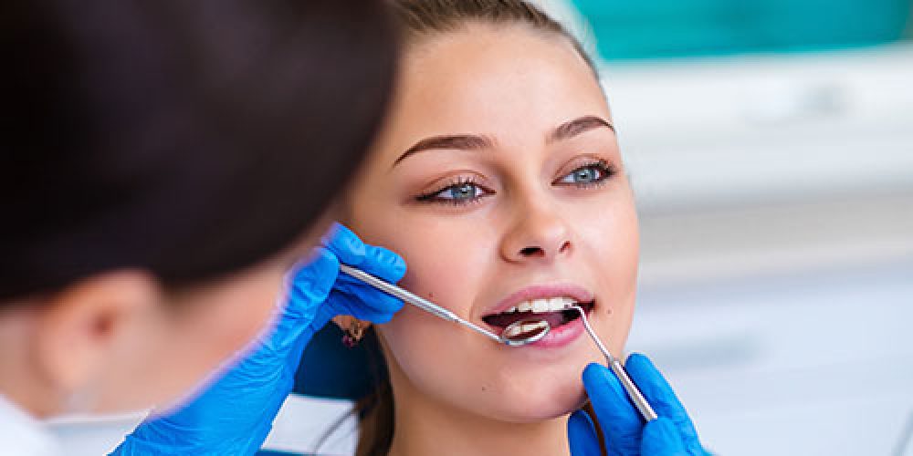 Dentista revisando la boca de una chica