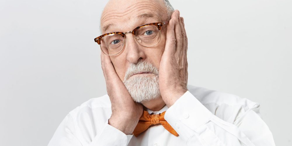 Hombre con dolor de muelas sosteniéndose la cabeza